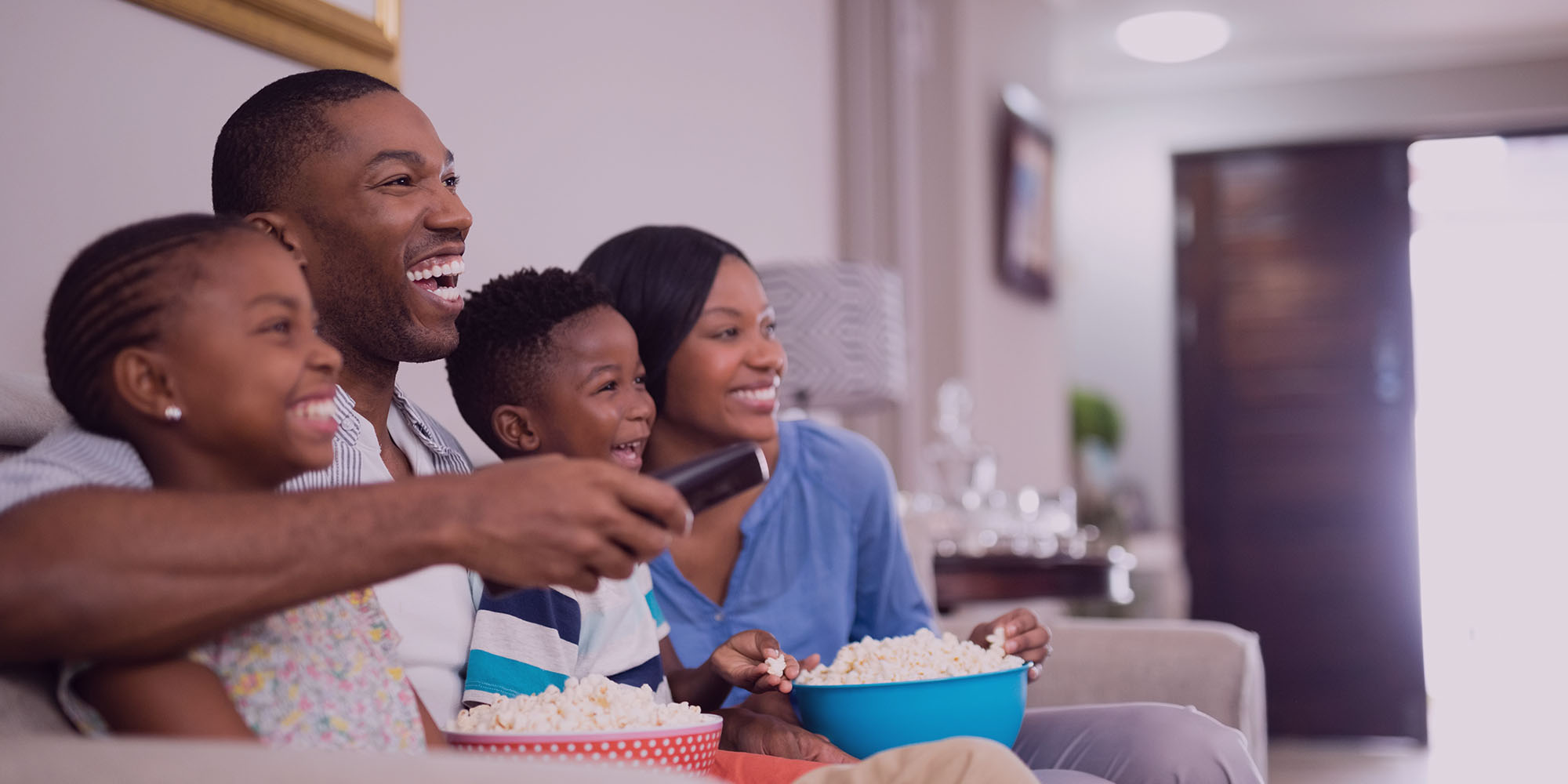 Famille assis à regarder un film à domicile